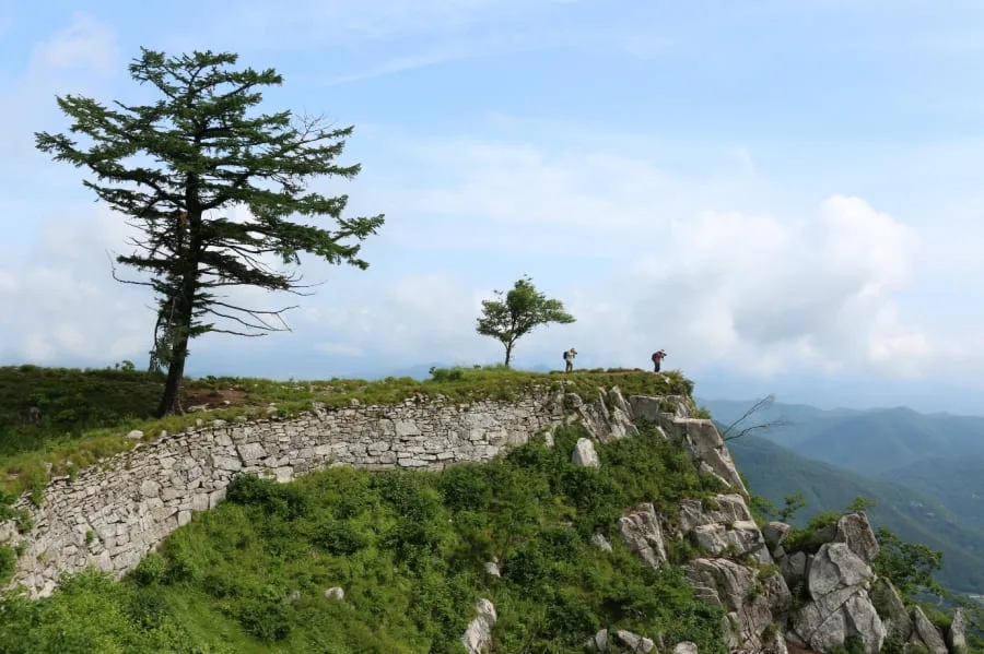 두명의-등산객이-가산산성-꼭대기에서-사진을-찍고-있다.