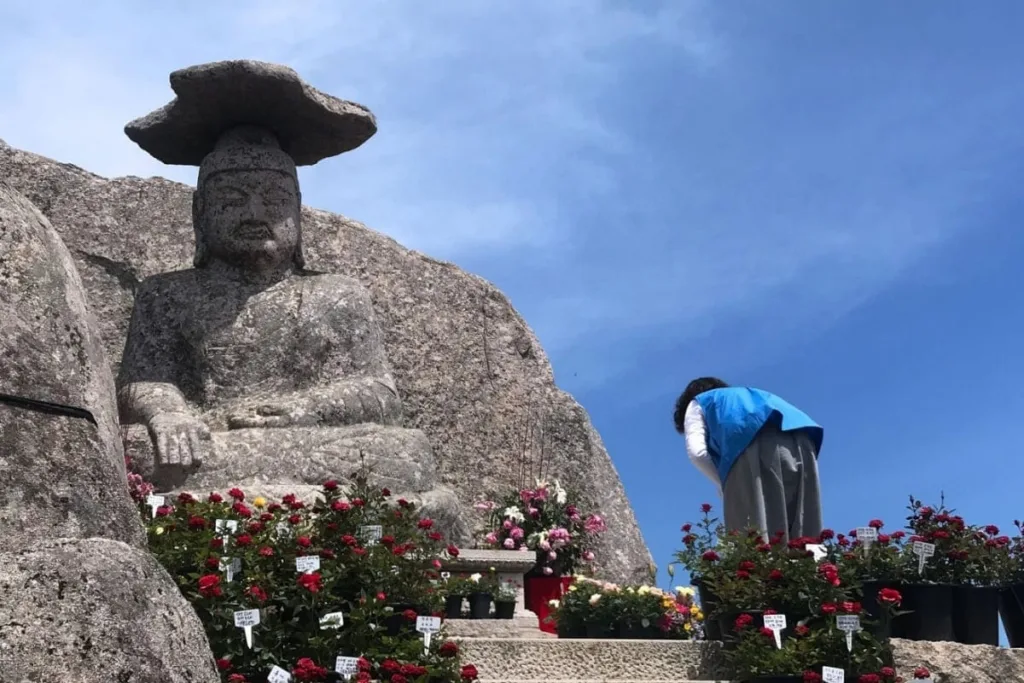 갓바위에-방문객이-고개숙여-인사한다.