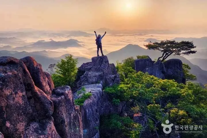 등산객이-대둔산-바위에-올라-일출을-바라본다.