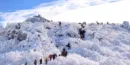 등산객이-눈쌓인-산을-줄지어-올라간다.