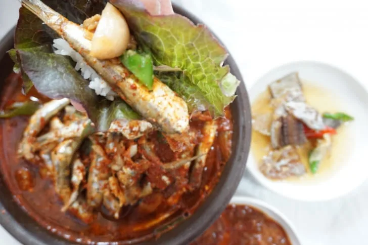 상추에-멸치쌈을-올리고-있다.