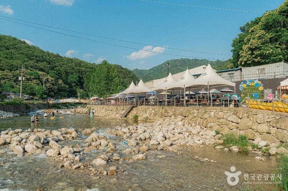 백운계곡-인근에-파라솔과-탁자가-놓여있다.
