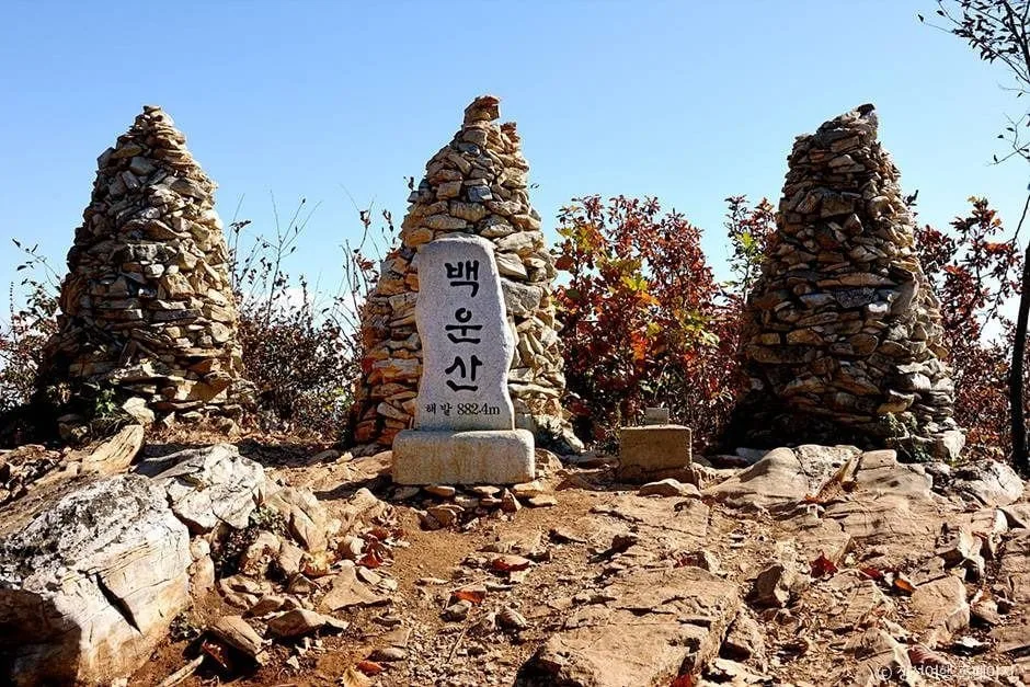 돌탑과-백운산-정상석이-놓여있다.