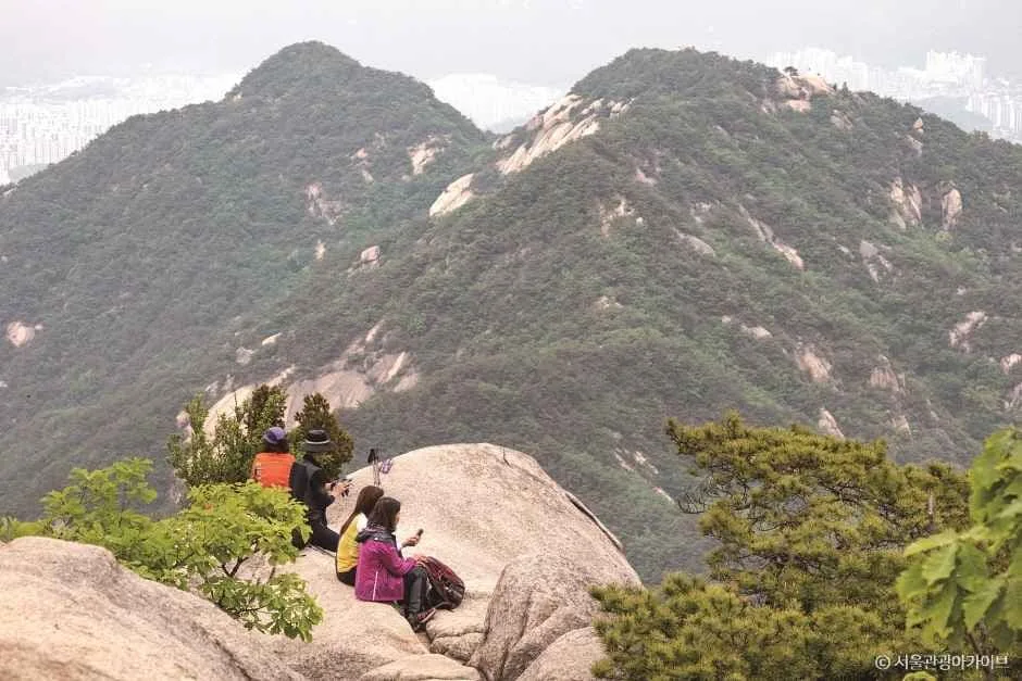 등산객들이-수락산-정상에-앉아-쉬고-있다.