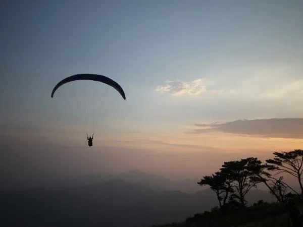 노을진-하늘에-패러글라이딩이-활강 중이다.