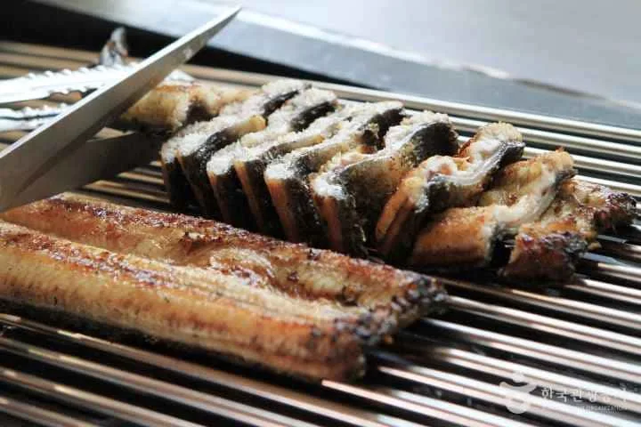 구운-장어를-가위로-자르고-있다.