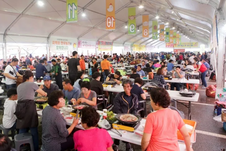 행사장에서-사람들이-불판에-한우를-구워먹고-있다.